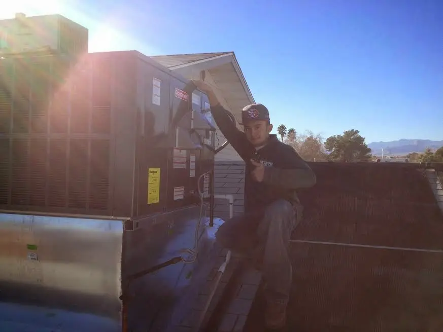 HVAC technician performing AC Tune-Up on a rooftop unit in Garfield